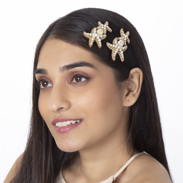 model wearing handmade gold shell beaded bobby pin set
