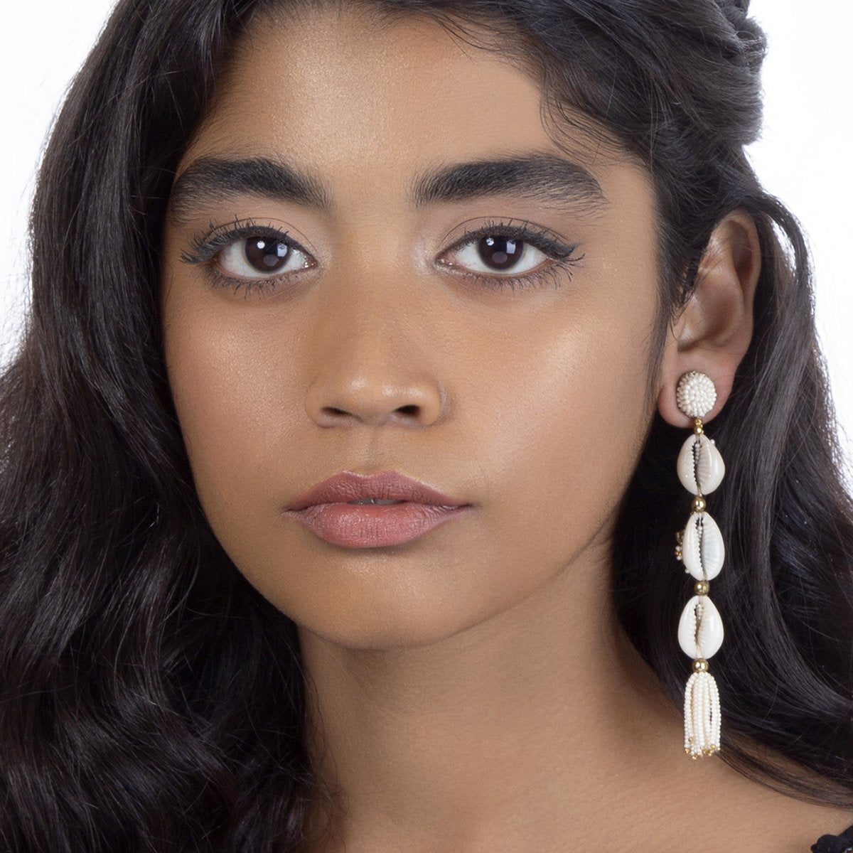 Model wearing Shell earrings with beaded tassel